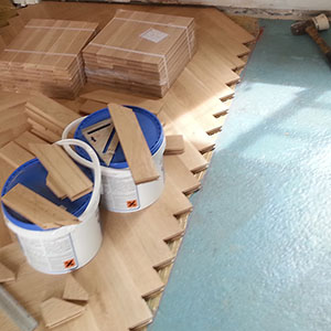 Installing parquet flooring bonded with flexible parquet adhesive